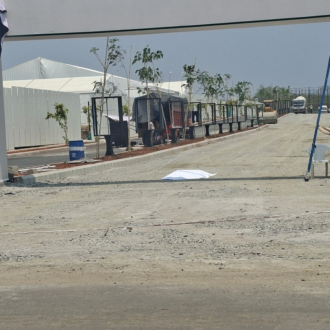 On-site Construction Progress at Prestige Golden Grove Active construction site at Prestige Golden Grove showing heavy machinery, large white temporary structures, and the installation of black metal frames along a gravel path.